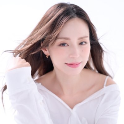 白いシャツを着て微笑んでいる女性のポートレートです。