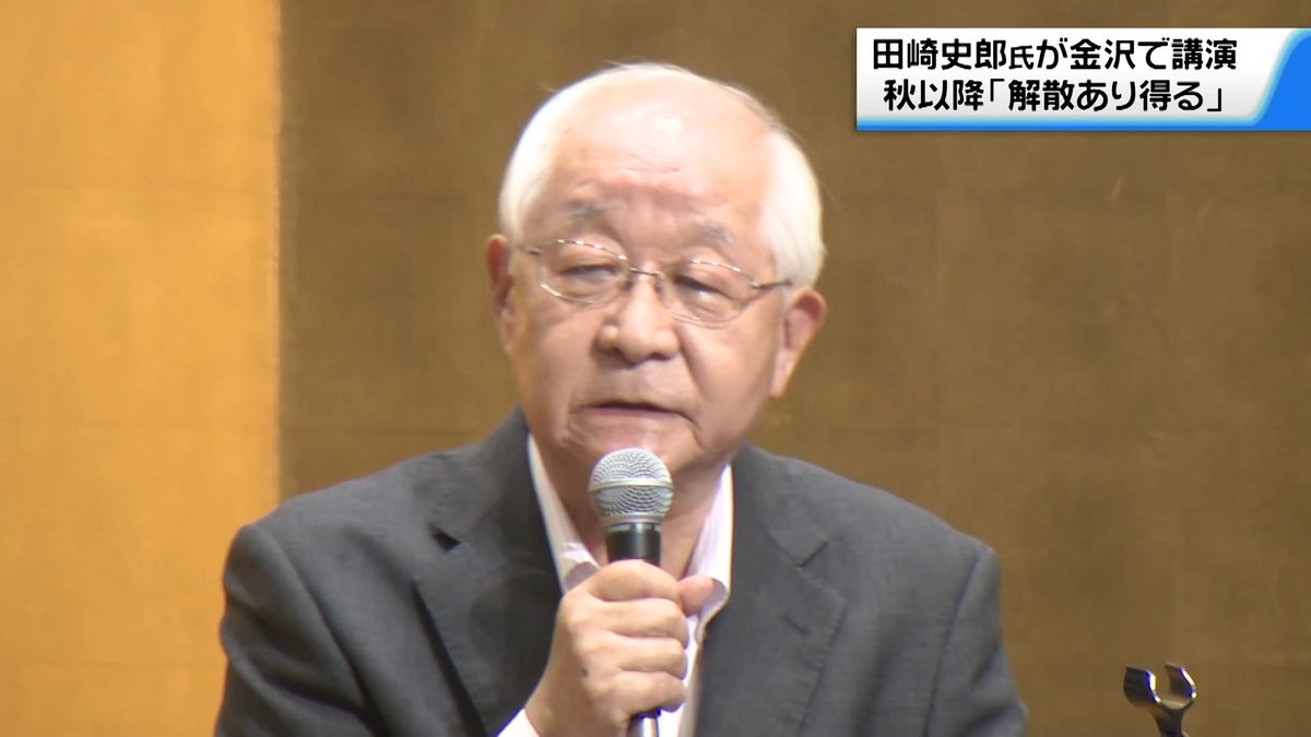 "マイクの前で講演する現在の田崎史郎氏。"
