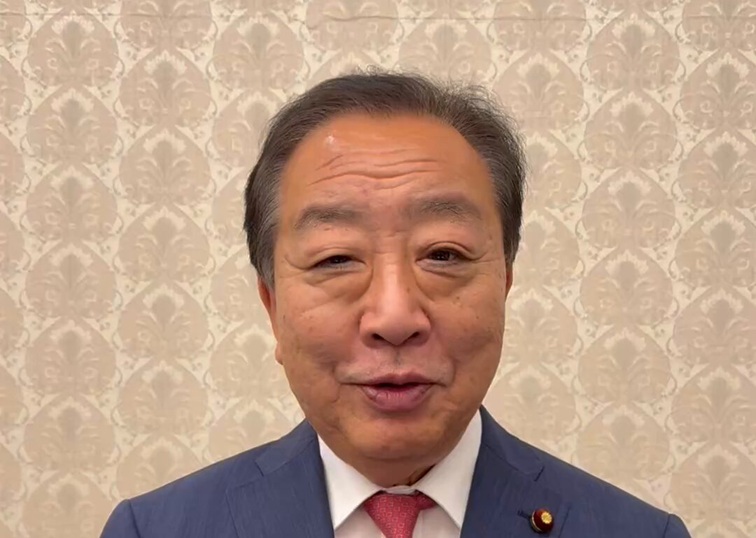 スーツを着用し、正面を向いて穏やかに話しているように見える野田佳彦氏の近影。