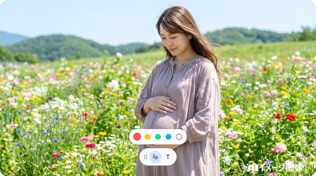 花畑でふっくらとしたお腹を優しく抱え、幸せな微笑みを浮かべる日本人女性のマタニティイメージ
